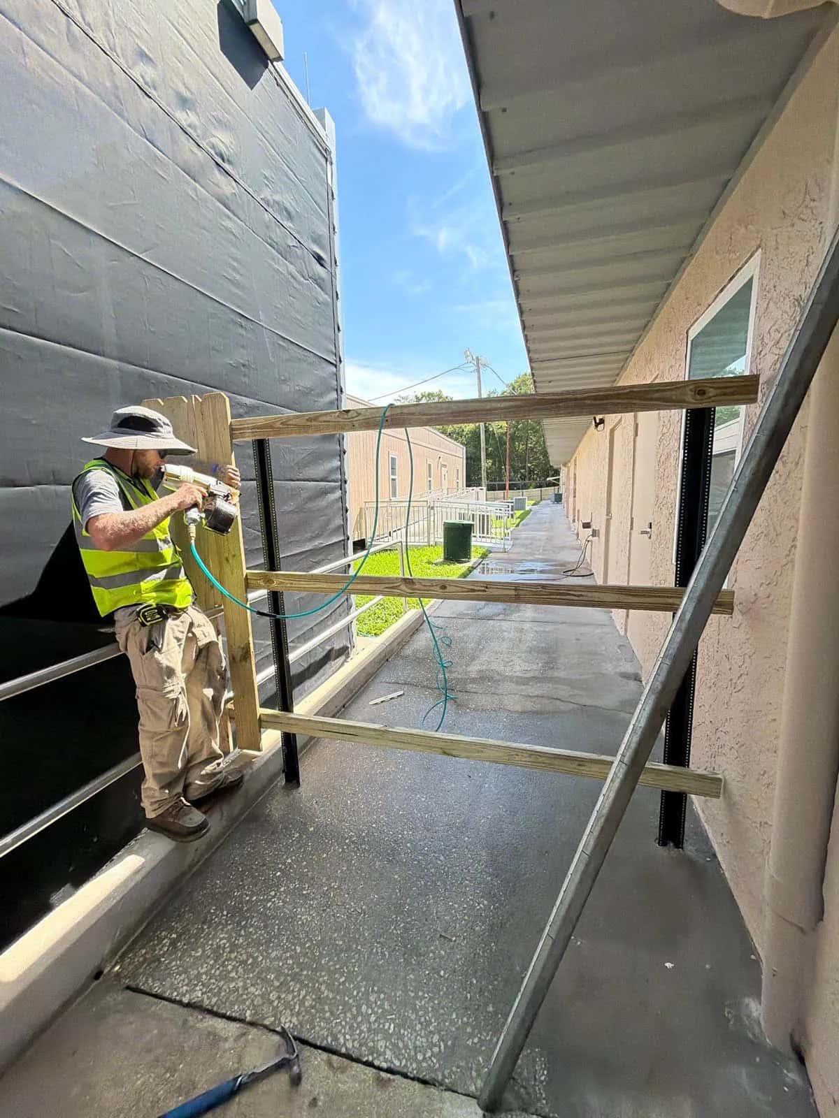Swi Florida Crew Member Installing Stockade Wood Privacy Fence Commercial Walkway